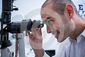 Optometrist looking through biomicroscope