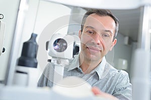 optometrist with non contact tonometer checking patient intraocular pressure