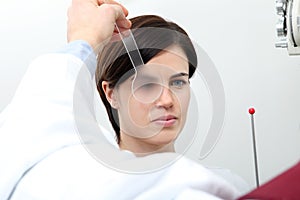 Optometrist optician doctor examines eyesight of woman patient