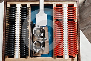 Optometrist prepares a set of ophthalmic trial lenses for vision testing and trial frame, open table with optometric