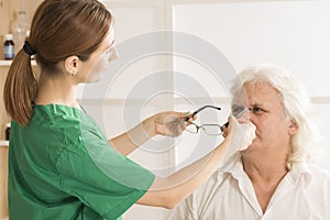Optometrist prescribing spectacles to elderly man