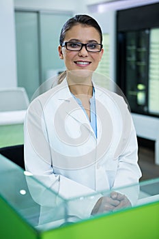 Optometrist in spectacles smiling in optical store