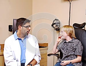 Optometrist talking with young lad