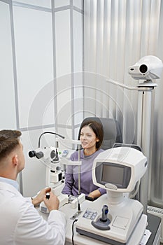 Optometrist Using Equipment while Examining Patient
