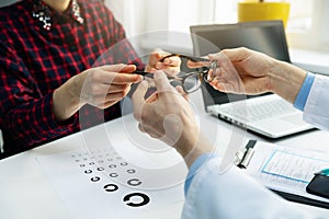 Optometrist visit - woman get her new glasses at optician office