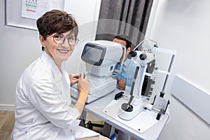 Optometrist in white scubs near refractometer