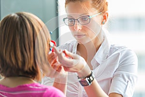 Optometry concept - pretty, young female optometrist photo