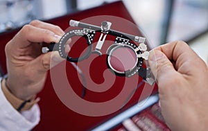 Optometry, healthcare and optometrist with trial lens for a eye test in a optical clinic. Vision, eyecare and hands with