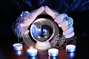 Oracle telling future gwith glass orb on a table