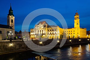 Oradea City Hall on embankment in twilight