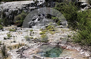 Orakei Korako hidden geothermal valley: View on cascade with steaming hot clear blue alkali chloride thermal pool