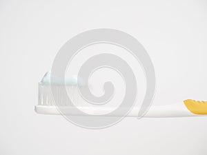 Oral concept. Close up yellow Toothbrush With blue Toothpaste.