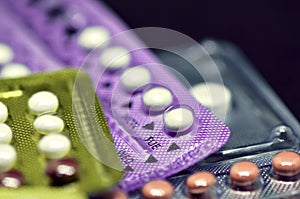 Oral contraceptive pill on black background.