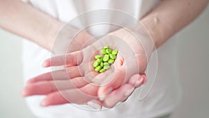 Oral contraceptives. Green pills in women`s hands close up. Protection from unwanted pregnancies