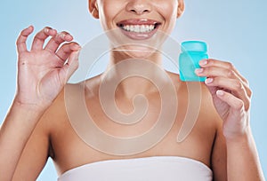 Oral, dentist and flossing product of woman with clean, white teeth in a studio blue background mockup. Young model