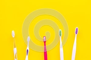 Oral hygeine. Toothbrushes on yellow background top view copy space