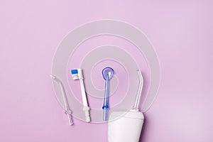 Oral hygiene set Oral teeth irrigator dental floss tongue scraper Pink background Dental care treatments daily routine Horizontal