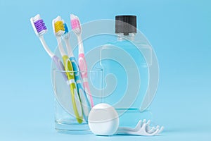 Oral hygiene. Toothbrush, dental floss and rinse for mouth and teeth on a gentle blue background