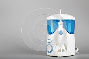 Oral irrigator on a gray background.
