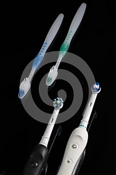 Oralcare Concepts. Pair of Electric and Manual Toothbrushes Together Over Black Background