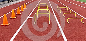 Orang cones and yellow mini hurdles set up on a track