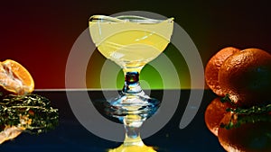 Orange alcohol cocktail in a glass on colorful wall background. Stock clip. Cold refreshing drink and a bar counter with