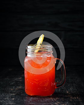 Orange alcoholic cocktail. Orange juice, rum, grenadine, orange. On a wooden background.