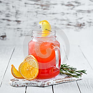 Orange alcoholic cocktail. Orange juice, rum, grenadine, orange. On a wooden background.