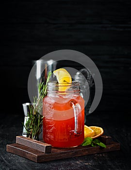 Orange alcoholic cocktail. Orange juice, rum, grenadine, orange. On a wooden background.