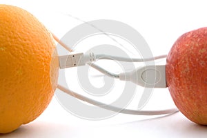 The orange and apple are connected through a cable