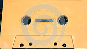 Orange audio cassette tape with a blank label