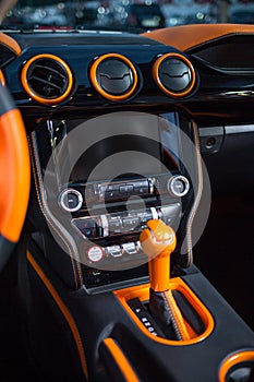 Orange automatic shifter and the front panel of the salon inside the car.