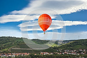 Orange balloon amid blue sky . soar in the clouds