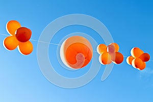 Orange balloons against a blue sky