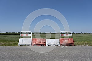 Orange barrels, barricades, and signs blocking a road