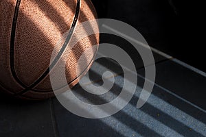 An orange basketball ball on a dark blue floor.