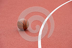 Orange basketball on brown court of gymnasium sport floor. Street basketball concept