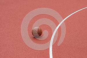 Orange basketball on brown court of gymnasium sport floor. Street basketball concept