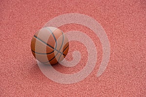 Orange basketball on brown court of gymnasium sport floor. Street basketball concept