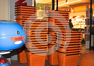 Orange baskets with which to shop at the supermarket stacked at the entrance to the store