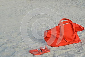 Orange beach bag and flip flops
