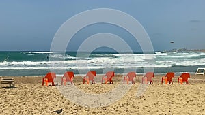 Orange beach chairs and sea surf