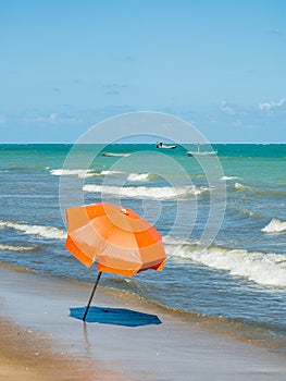 Orange beach umbrella near the shorebreak