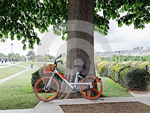 Orange bicycle with basket in the Tuileries Garden Jardin des Tuileries, Paris.