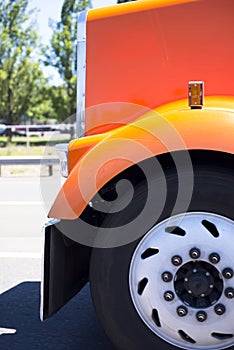 Orange big rig semi truck hood fender and wheel