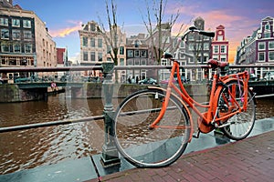 Orange bike along the canals in Amsterdam the Netherlands