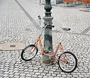 Orange bike chained to a pole