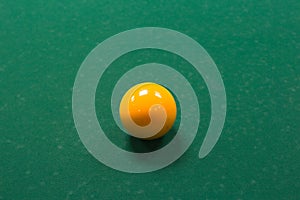 Orange billiard ball on a green table