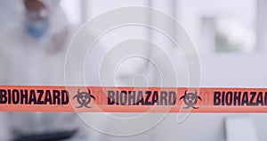 Orange biohazard barrier tape blocking and barricading a secured office space as a caution for disinfection of covid