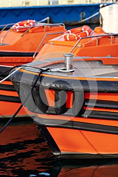 Orange and black boats moored in the port - Italy